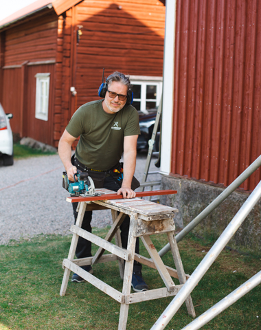 En handyman från Hus och Hemservice som hjälper en kund att byta panel på huset.